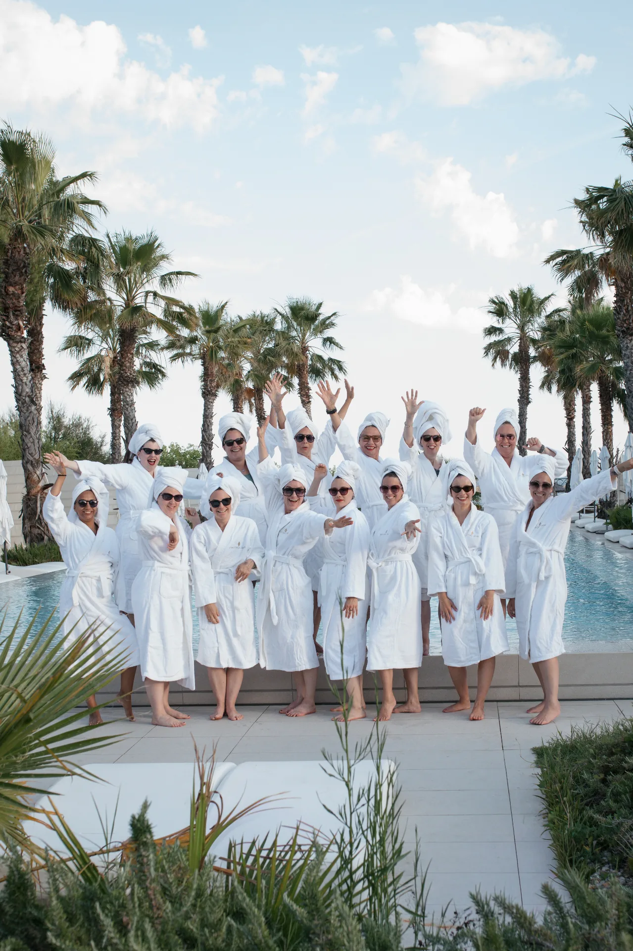 Gruppe von Unternehmerinnen im Bademantel am Pool bei der FEMINDS Workation