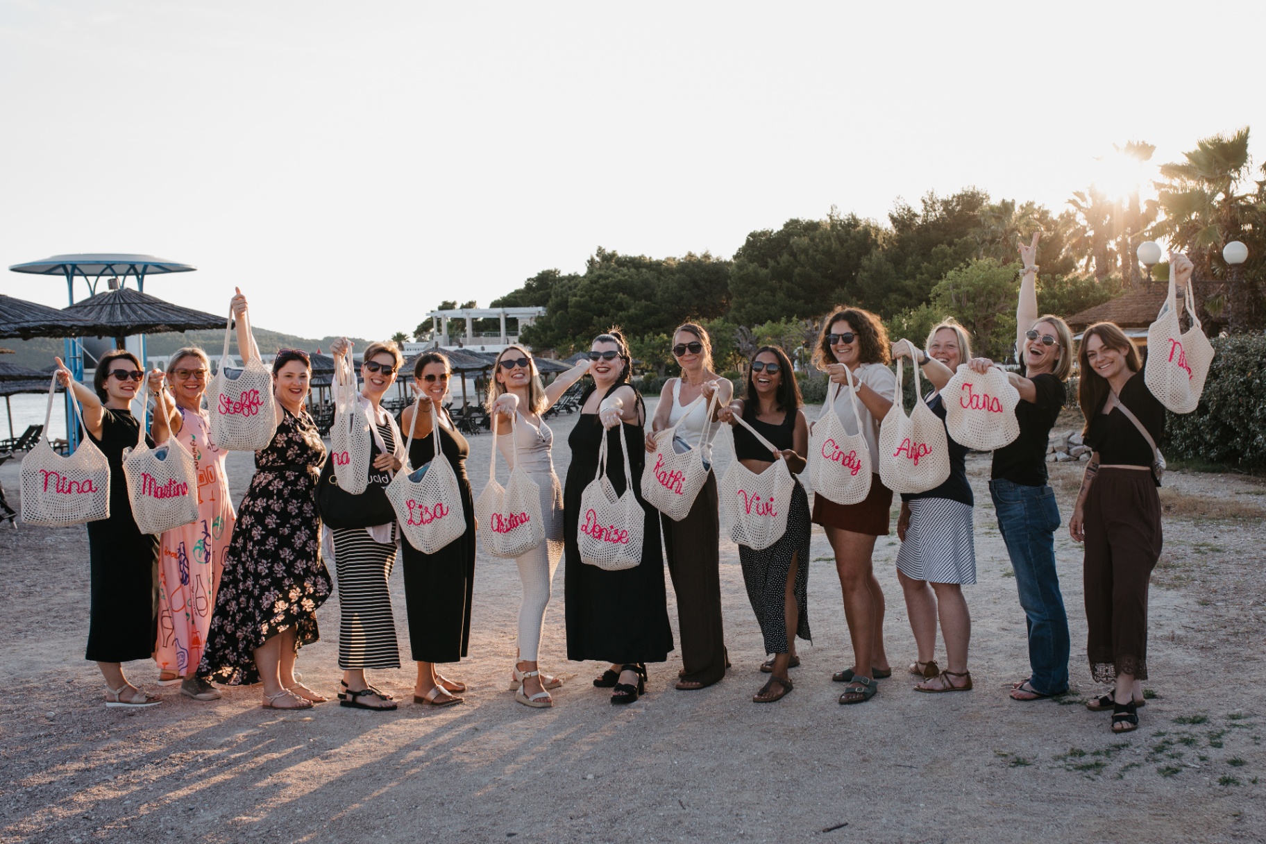 Gruppenfoto am Strand mit personalisierten Taschen